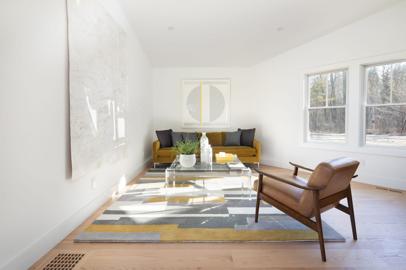 Light-filled living room with a mid-century lounge chair and low sofa