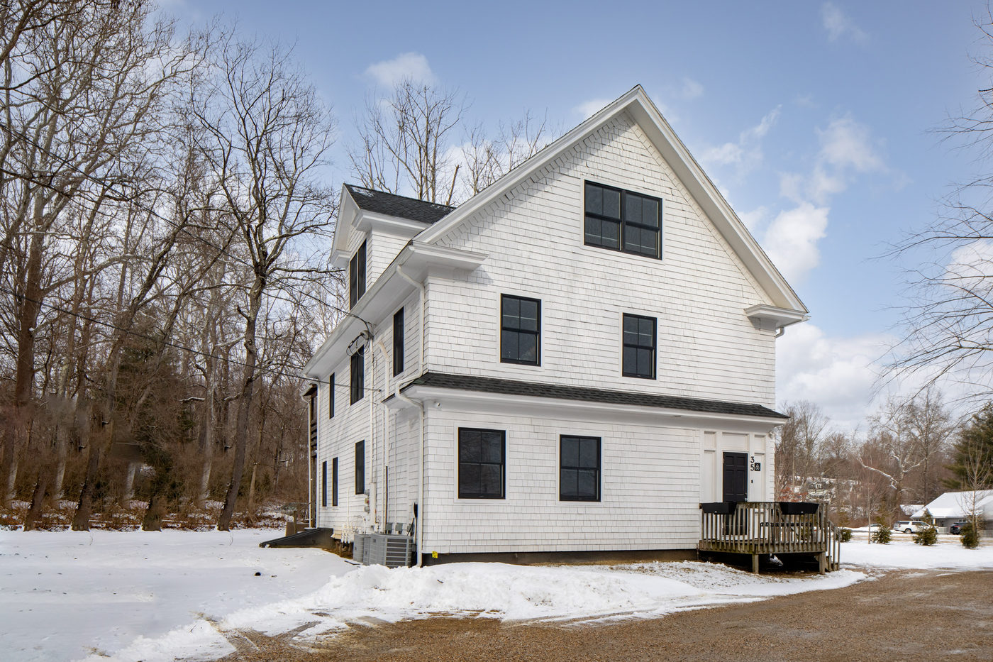 White clapboard building with black-framed windows on a winter day