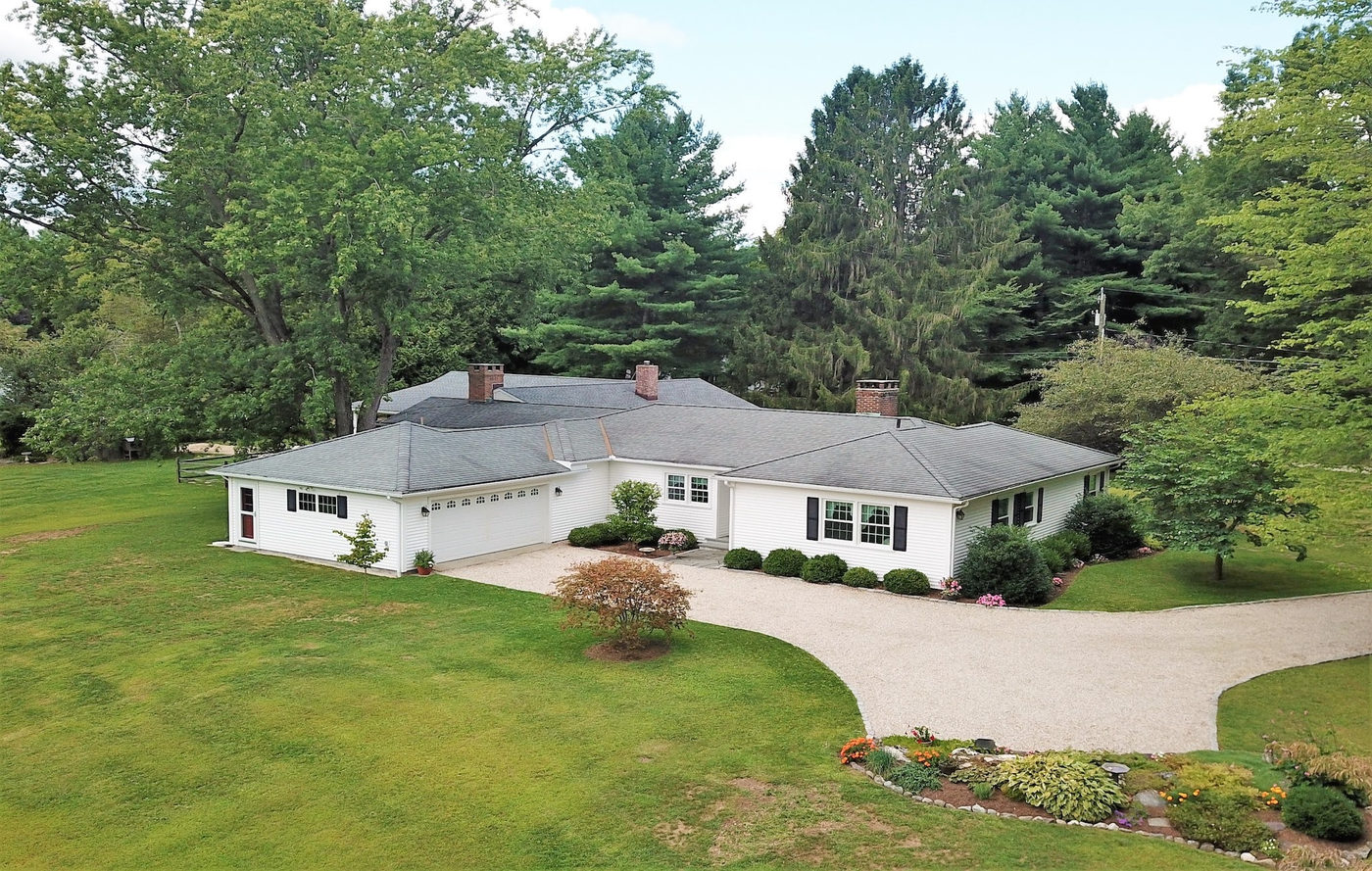 Renovated ranch house with a curved gravel drive and clipped plantings