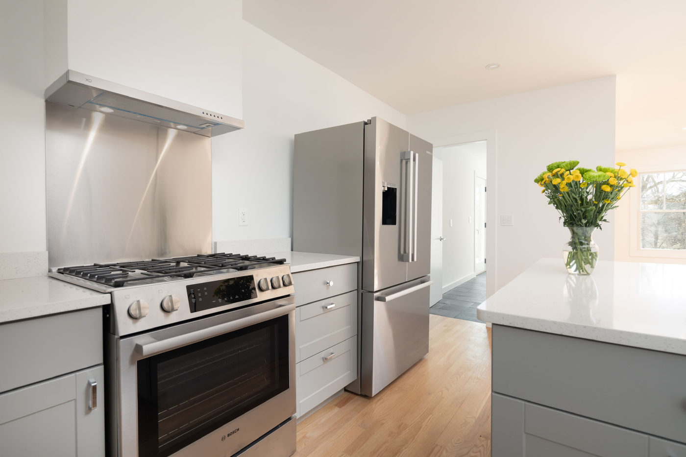 Kitchen with a stainless range, extractor hood and a marble-topped island