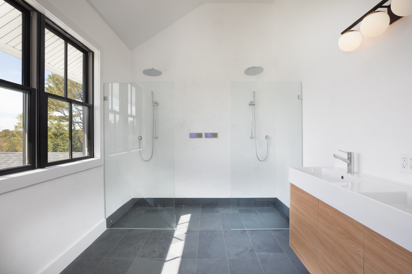 Bathroom with slate tile floor, wall-hung walnut vanity and a walk-in shower