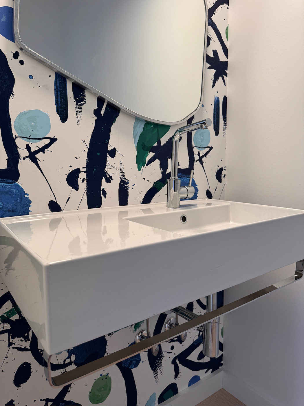 Powder room with hand-painted blue wallpaper and a wide trough sink
