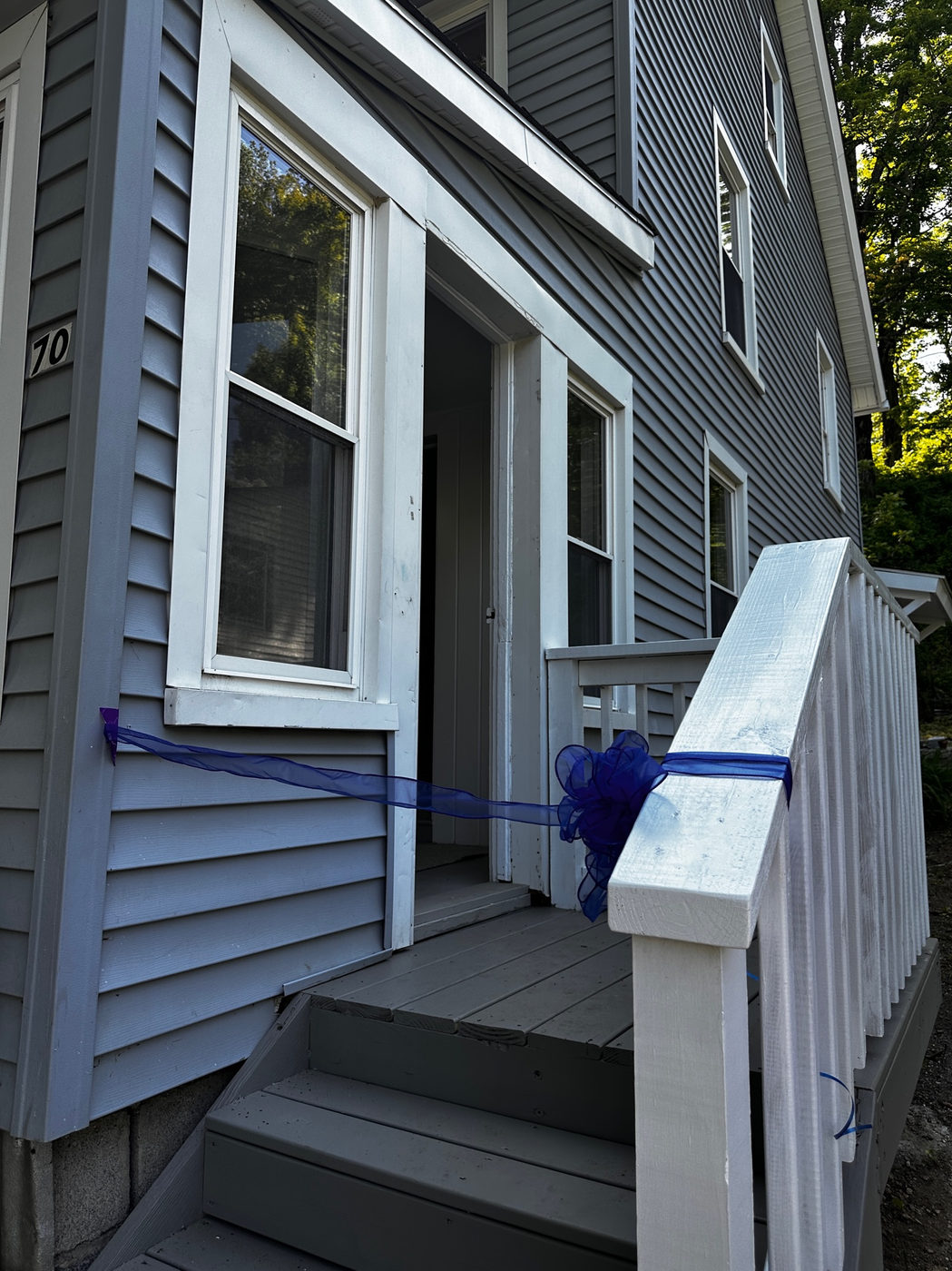 Entry steps of the grey clapboard house with white trim