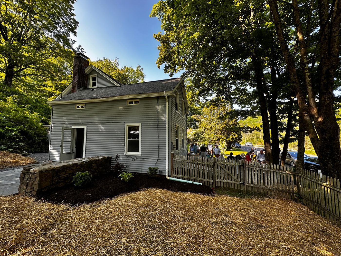Side of the grey house with new windows and painted trim