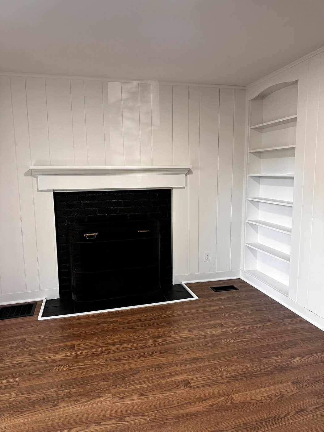 Study with a black fireplace surround and white built-in bookshelves