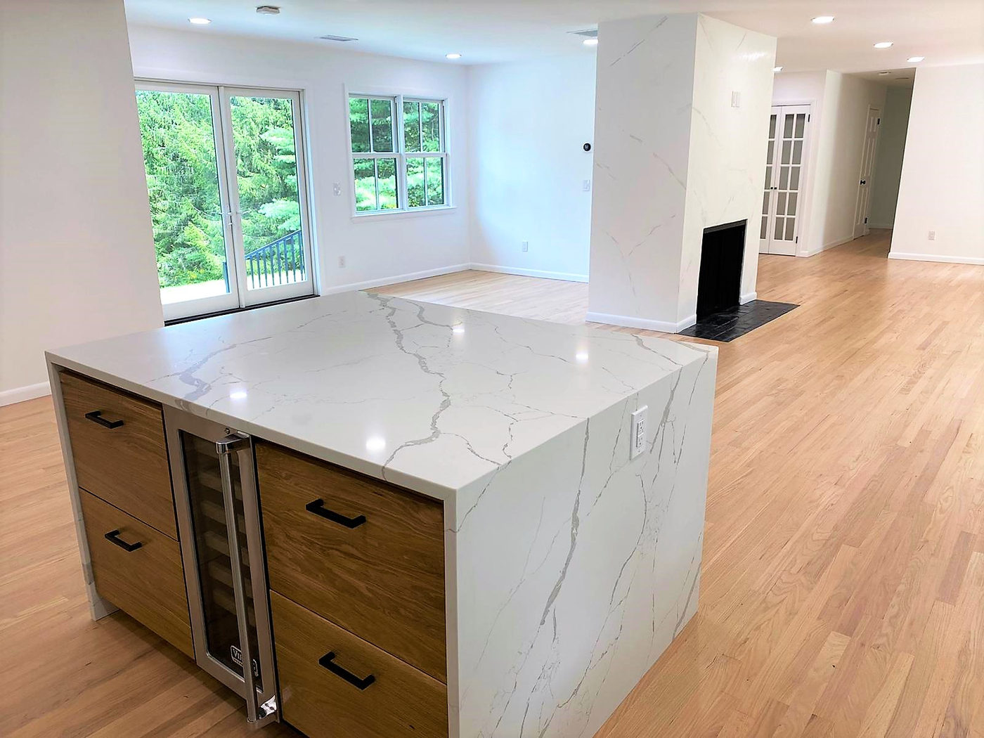 Marble island with walnut cabinetry and an integrated wine refrigerator