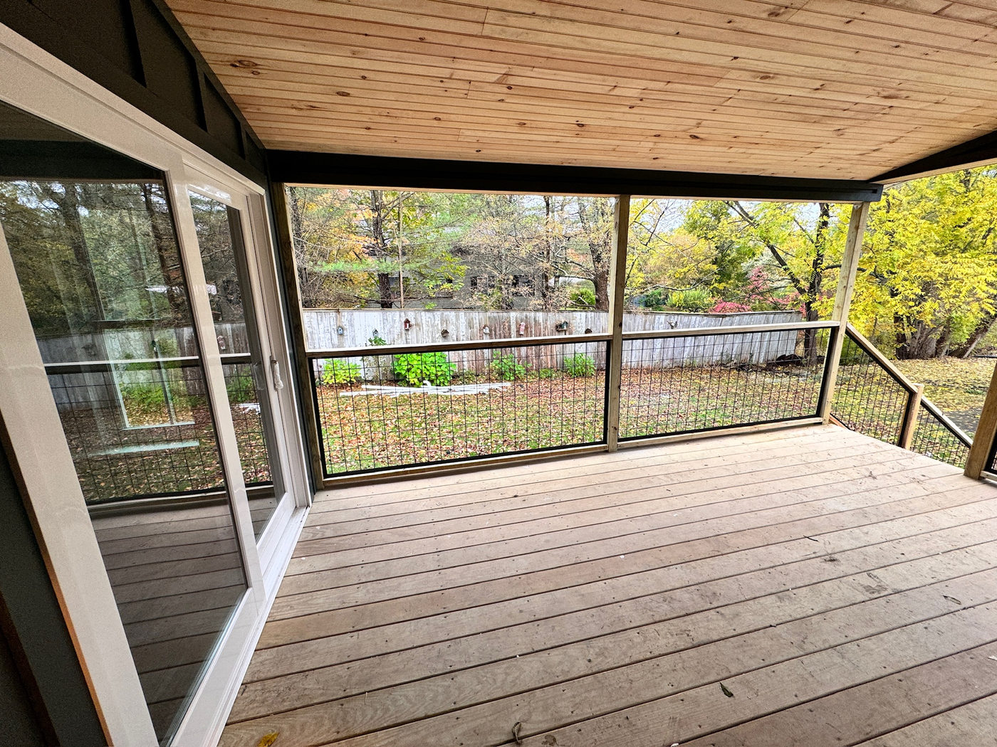 Screened porch with a pine ceiling and wide deck boards