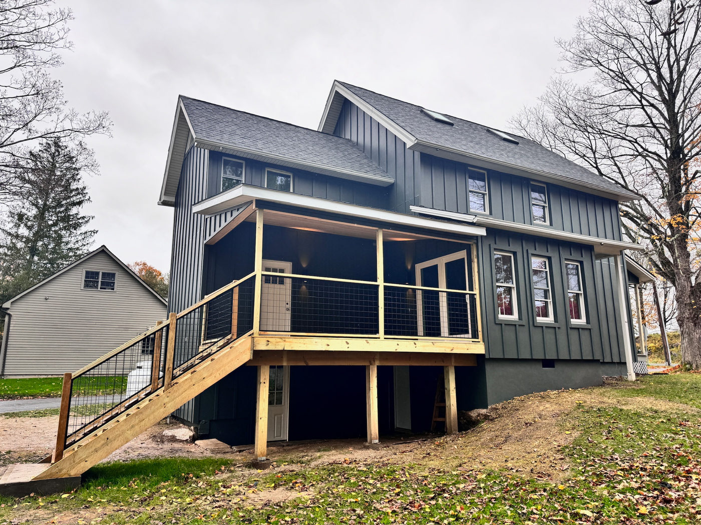 Side of the navy house with new siding and white-trimmed windows