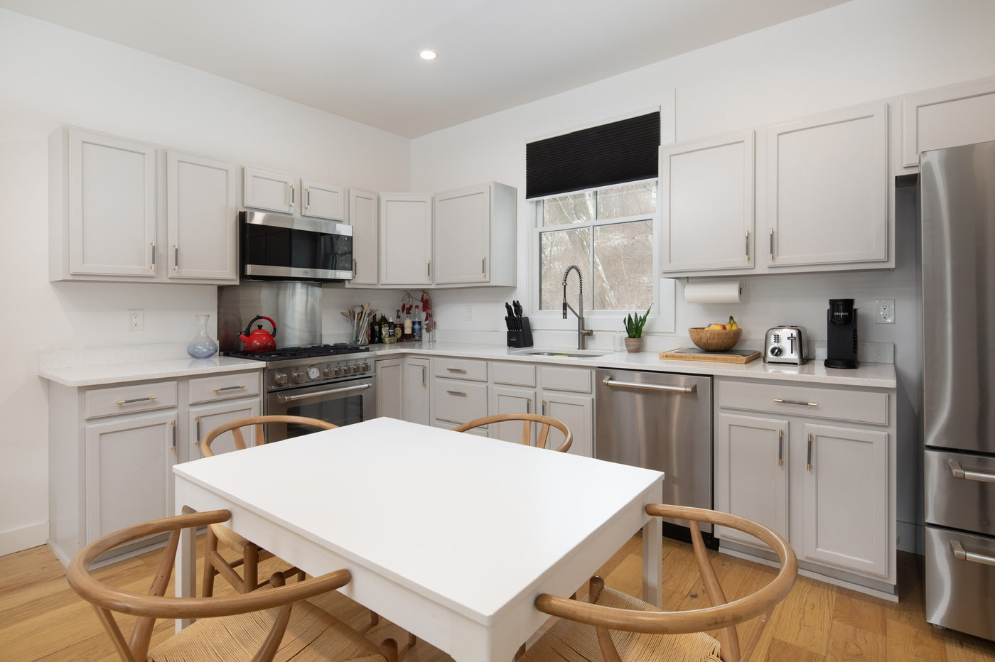 Kitchen with white cabinets, stainless appliances and a round dining table