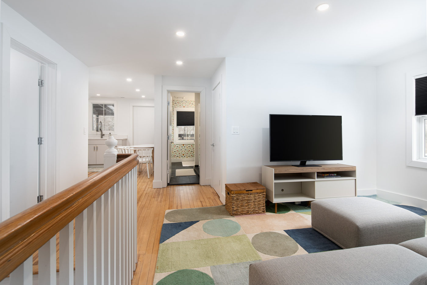 Apartment living area with a low sofa, oak floors and white walls