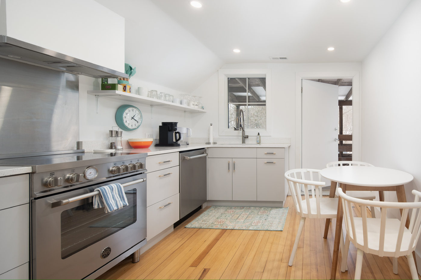 Kitchen with white cabinets, a stainless range and a round table