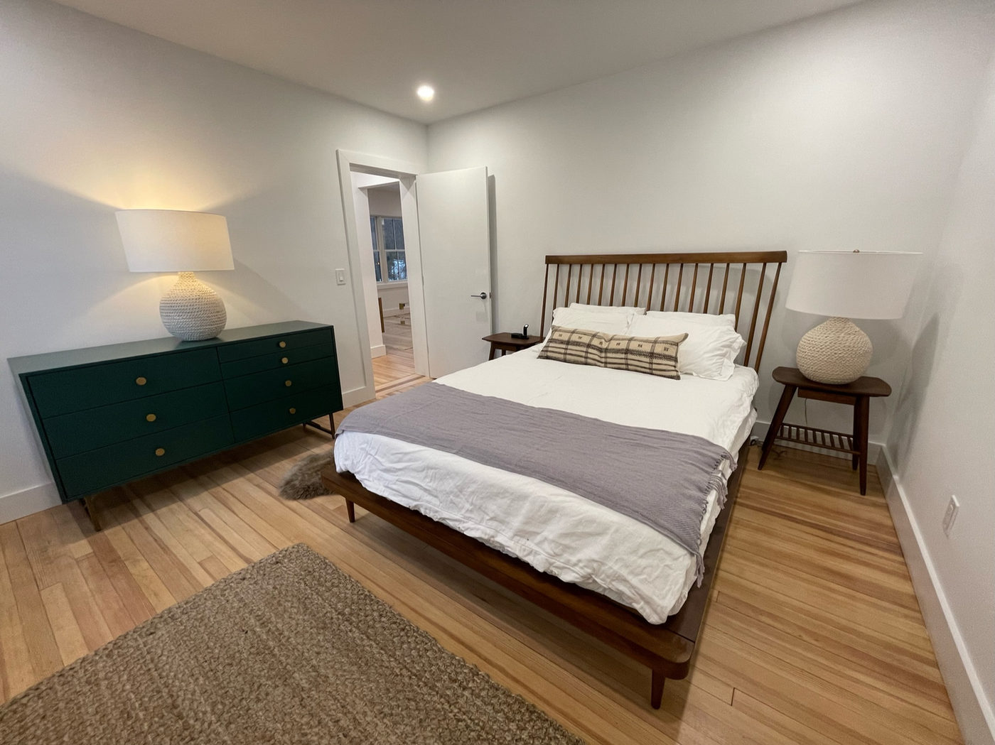 Second bedroom with a wooden bed frame and a green painted dresser